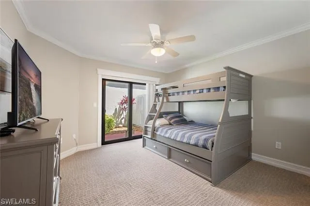 a bedroom with a bed and a flat tv screen on dresser