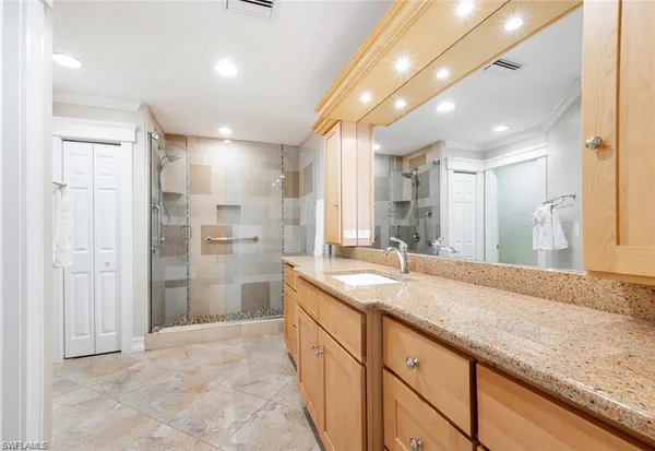 a bathroom with a granite countertop sink mirror and shower