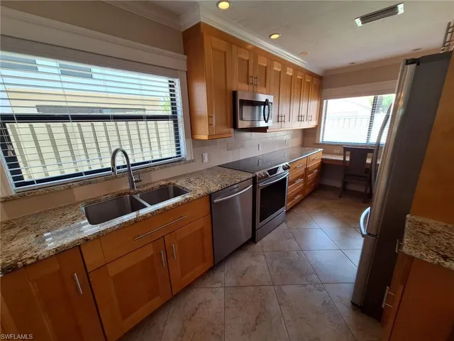 a large kitchen with stainless steel appliances granite countertop a sink and a stove