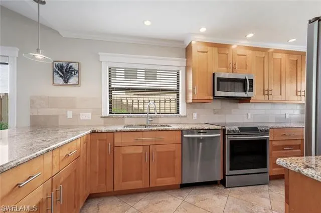 a kitchen with stainless steel appliances granite countertop wooden cabinets and a sink