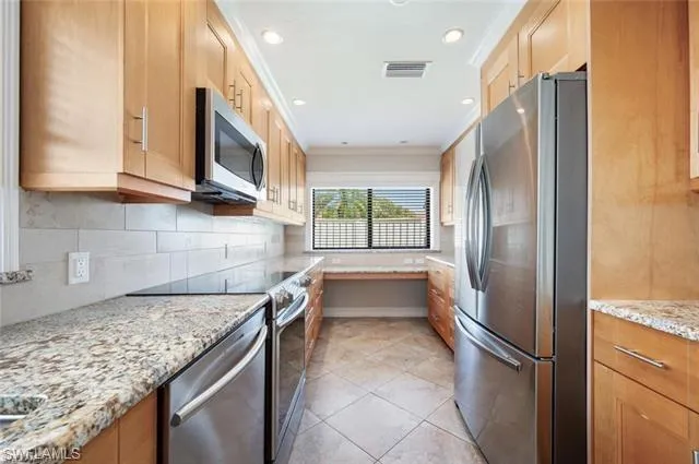 a kitchen with stainless steel appliances granite countertop a refrigerator and a sink