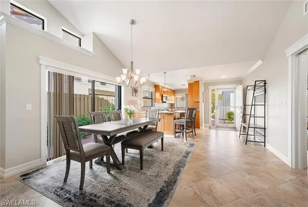 a dining room with furniture wooden floor a chandelier and a rug
