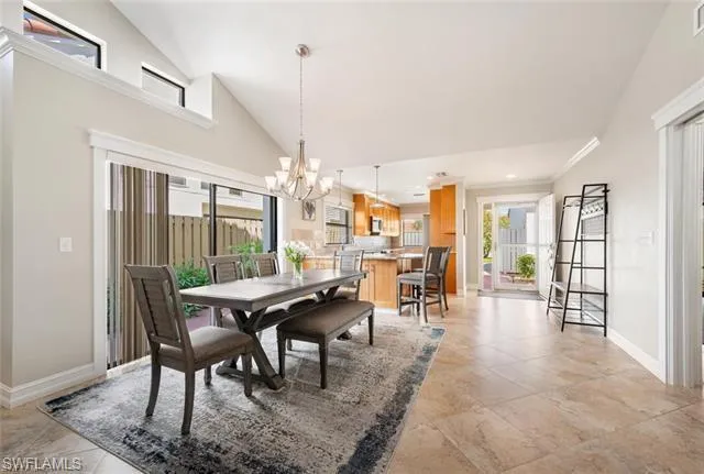 a dining room with furniture wooden floor a chandelier and a rug