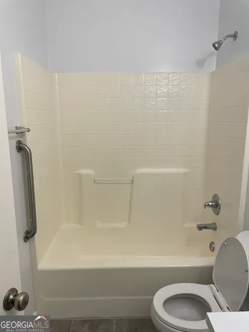 a bathroom with a toilet and a shower