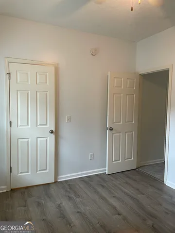 an empty room with wooden floor & windows
