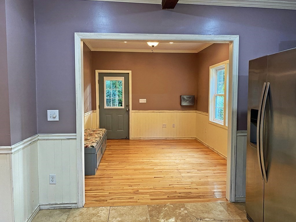 121 River Road Ware, MA 01082 - Photo 23 of 39 a view of a refrigerator in kitchen and an empty room with wooden floor