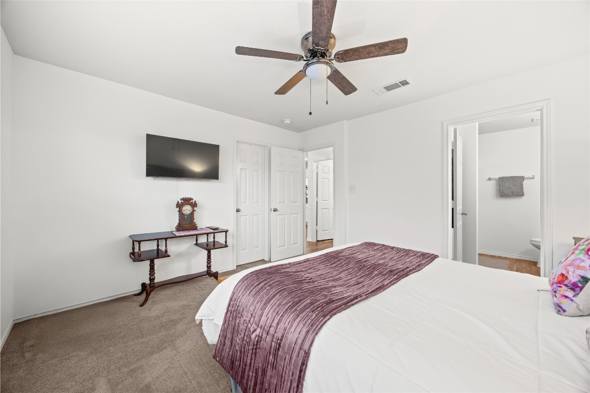 24026 Swather Way Hockley, TX 77447 - Photo 19 of 37 a bedroom with a bed a flat screen tv and furniture