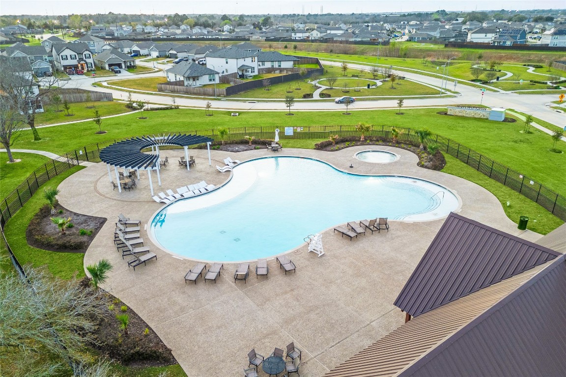 24026 Swather Way Hockley, TX 77447 - Photo 4 of 37 an aerial view of a swimming pool with a garden and lake view