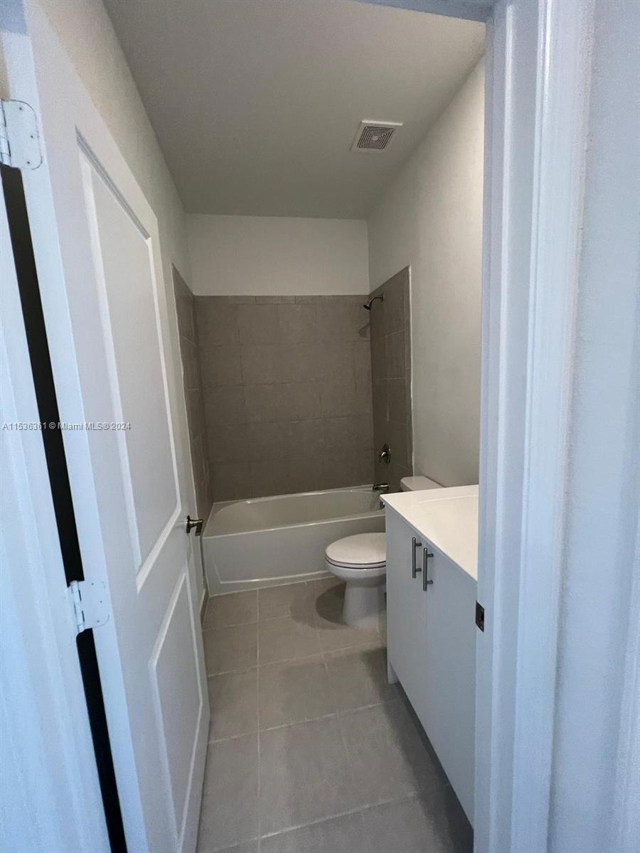11774 Southwest 246th Street, Unit 11774 Homestead, FL 33032 - Photo 5 of 17 a bathroom with a granite countertop sink toilet and shower