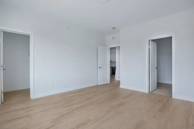 a view of an empty room with wooden floor
