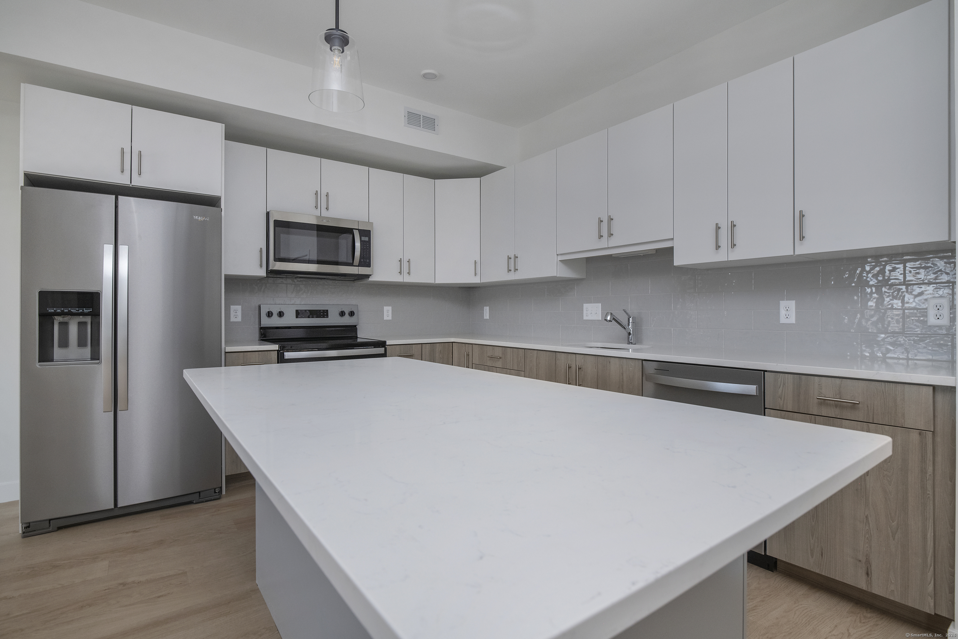 100 North Main Street, Unit 412 Bristol, CT 06010 - Photo 7 of 11 a kitchen with stainless steel appliances a refrigerator sink and white cabinets