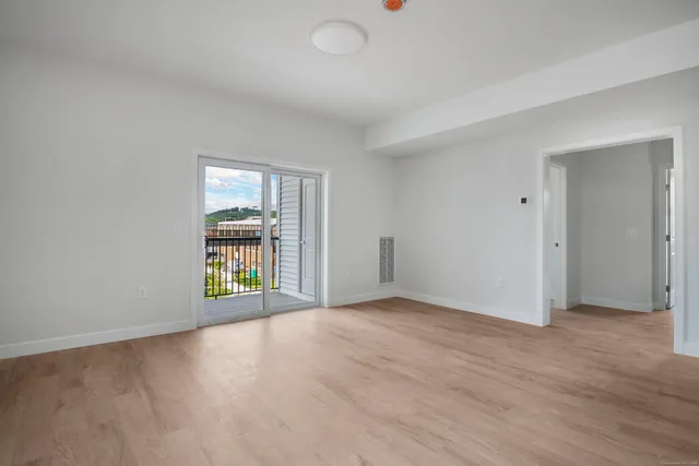 an empty room with a window and wooden floor