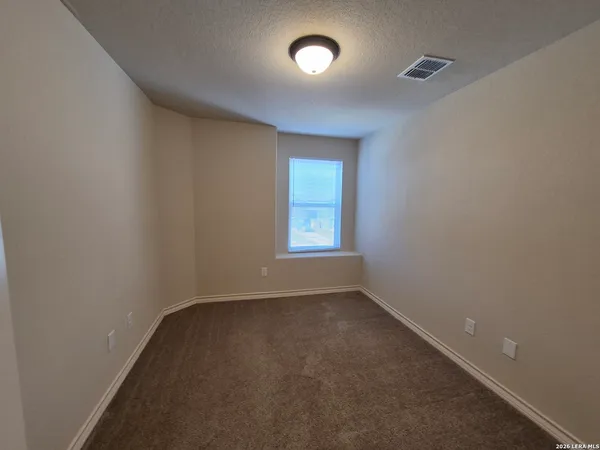 an empty room with closet and mirror