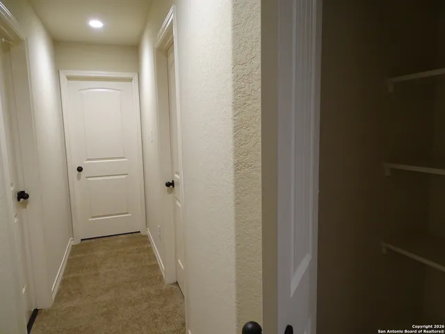 a view of a hallway with the wooden shelves