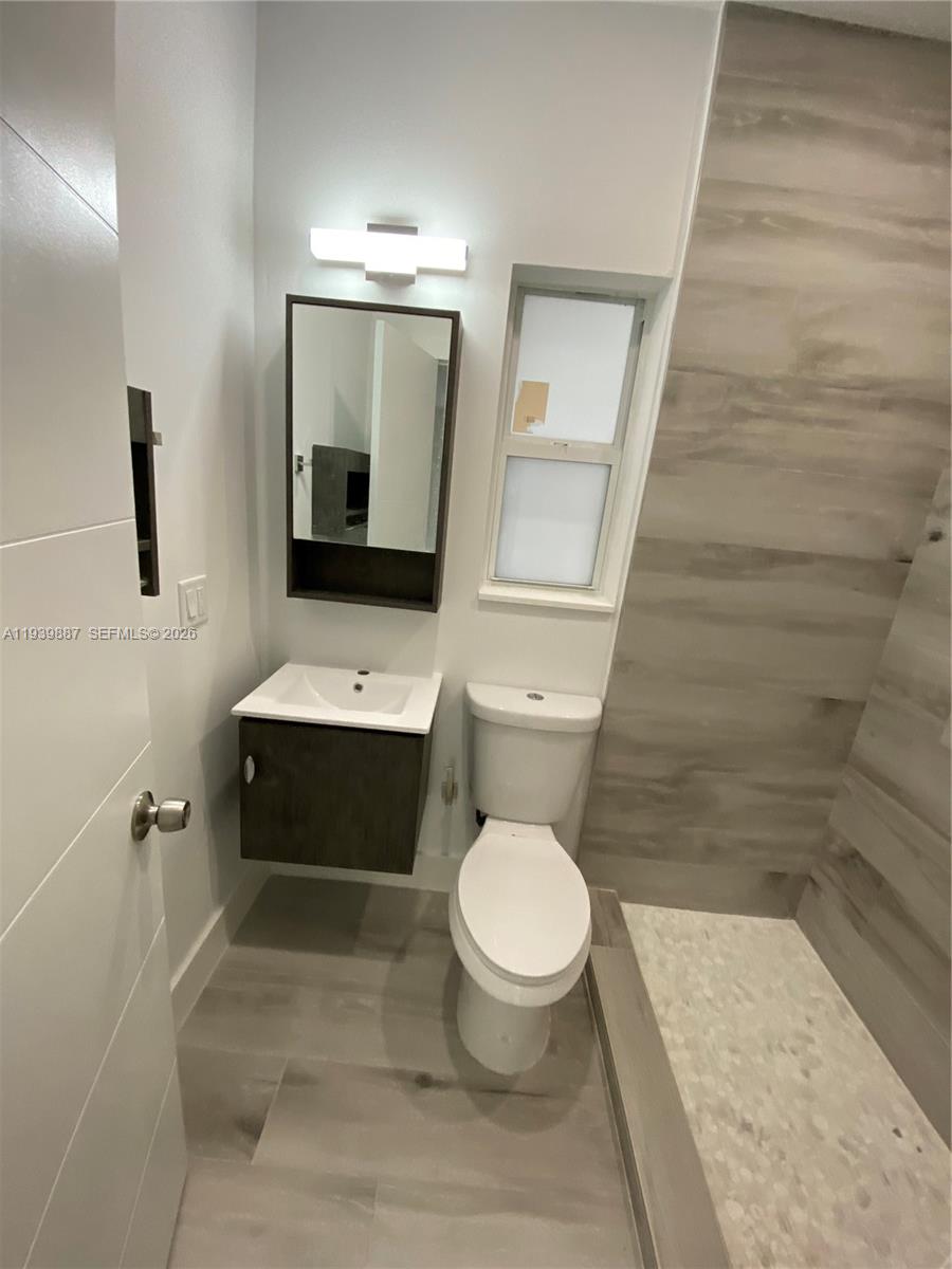 837 Southwest 8th Avenue, Unit 837 Miami, FL 33130 - Photo 6 of 8 a bathroom with a toilet a sink and mirror