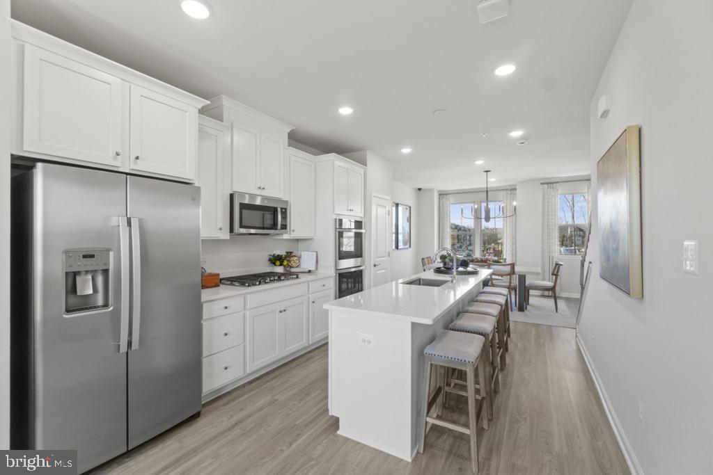 12535 Terrabrooke Avenue Brandywine, MD 20613 - Photo 13 of 32 a kitchen with white cabinets and stainless steel appliances