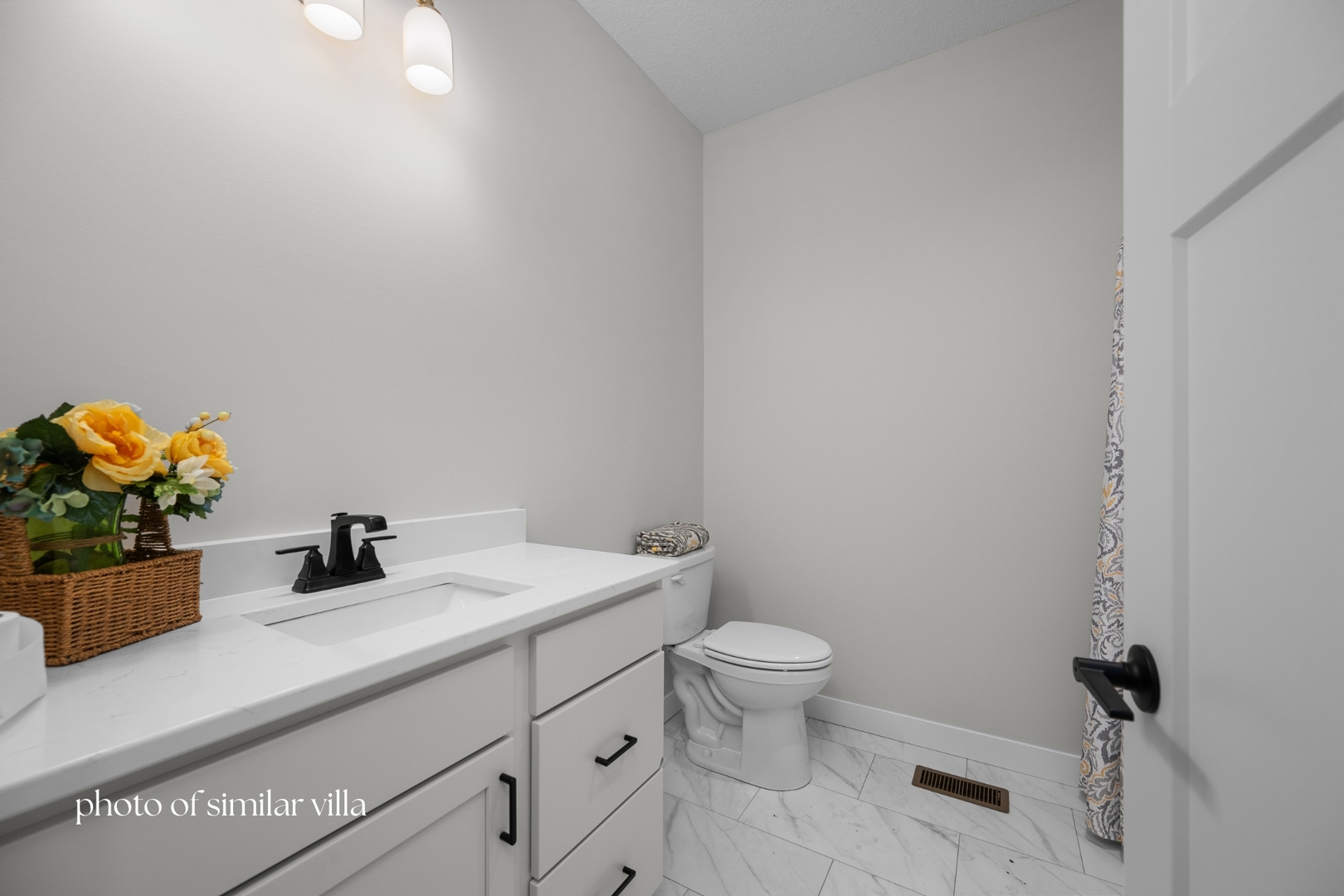 1867 Redbud Circle, Unit 101 Eldridge, IA 52748 - Photo 27 of 31 a bathroom with a sink a toilet and mirror