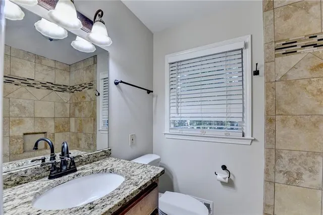 a view of an empty room with window and cabinet area