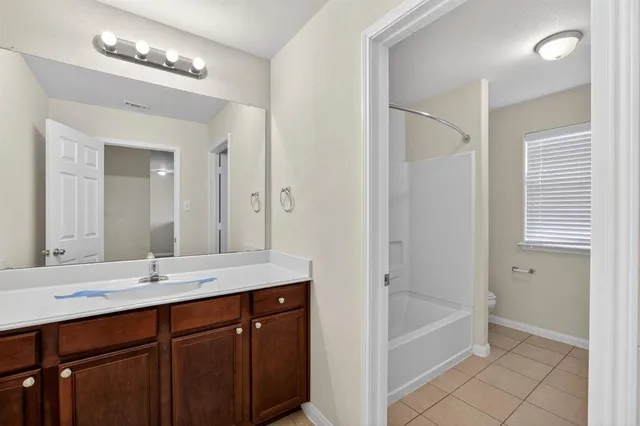 a bathroom with a tub a sink and a mirror
