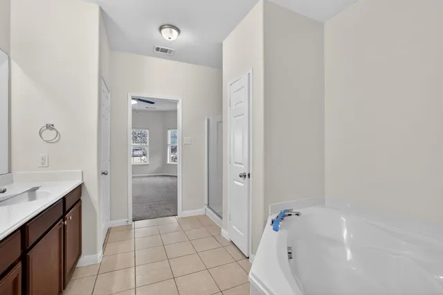 a bathroom with a tub sink and a mirror