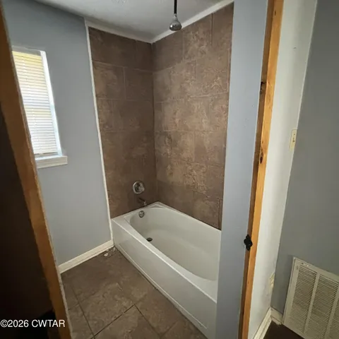 a white bath tub sitting next to a small sink
