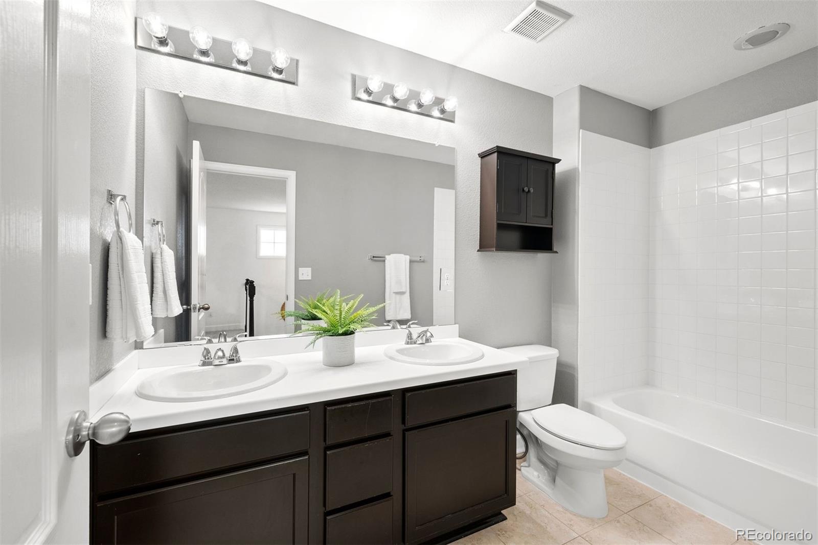 664 Tiger Lily Way Highlands Ranch, CO 80126 - Photo 29 of 47 a bathroom with a double vanity sink toilet and mirror