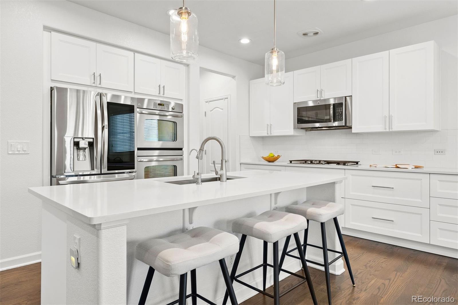 664 Tiger Lily Way Highlands Ranch, CO 80126 - Photo 9 of 47 a kitchen with stainless steel appliances a stove a sink and a refrigerator