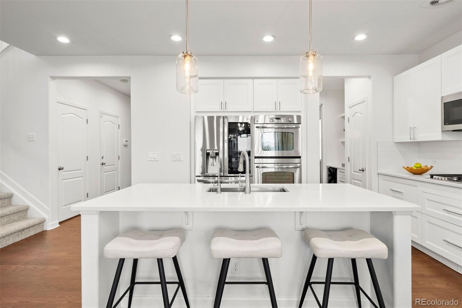 664 Tiger Lily Way Highlands Ranch, CO 80126 - Photo 10 of 47 a kitchen with stainless steel appliances kitchen island granite countertop a kitchen island and chairs in it