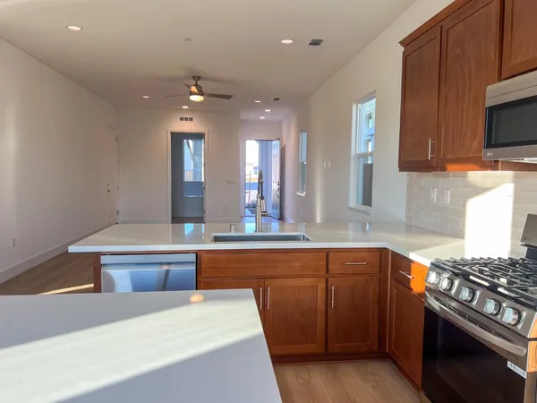 a kitchen with kitchen island granite countertop a stove and a sink
