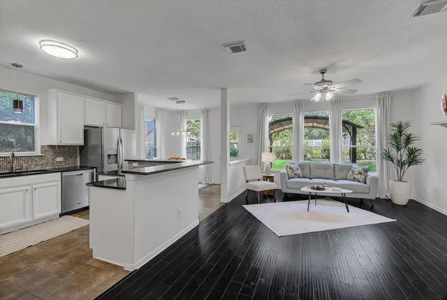 a kitchen with granite countertop a stove a sink a dining table and chairs
