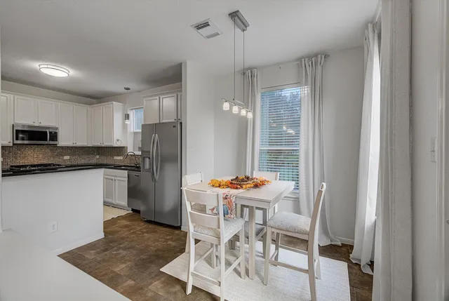 a kitchen with stainless steel appliances kitchen island granite countertop a refrigerator and a stove top oven