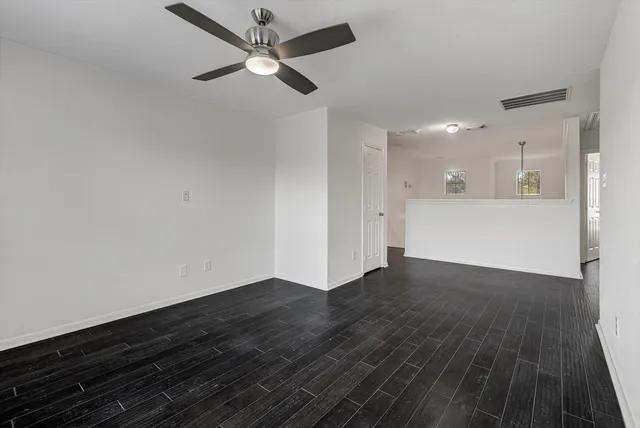 a view of empty room with wooden floor