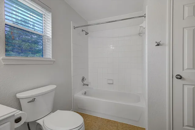 a white toilet sitting next to a bath tub shower