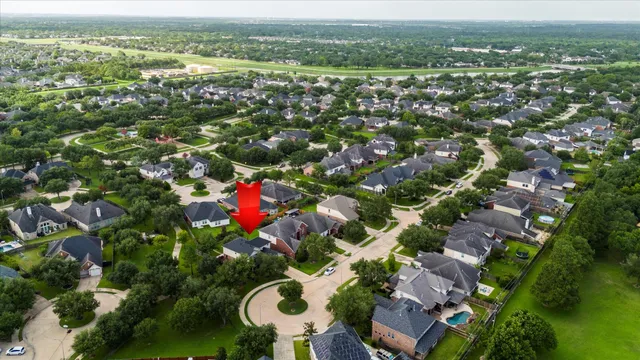 an aerial view of residential houses with outdoor space and trees