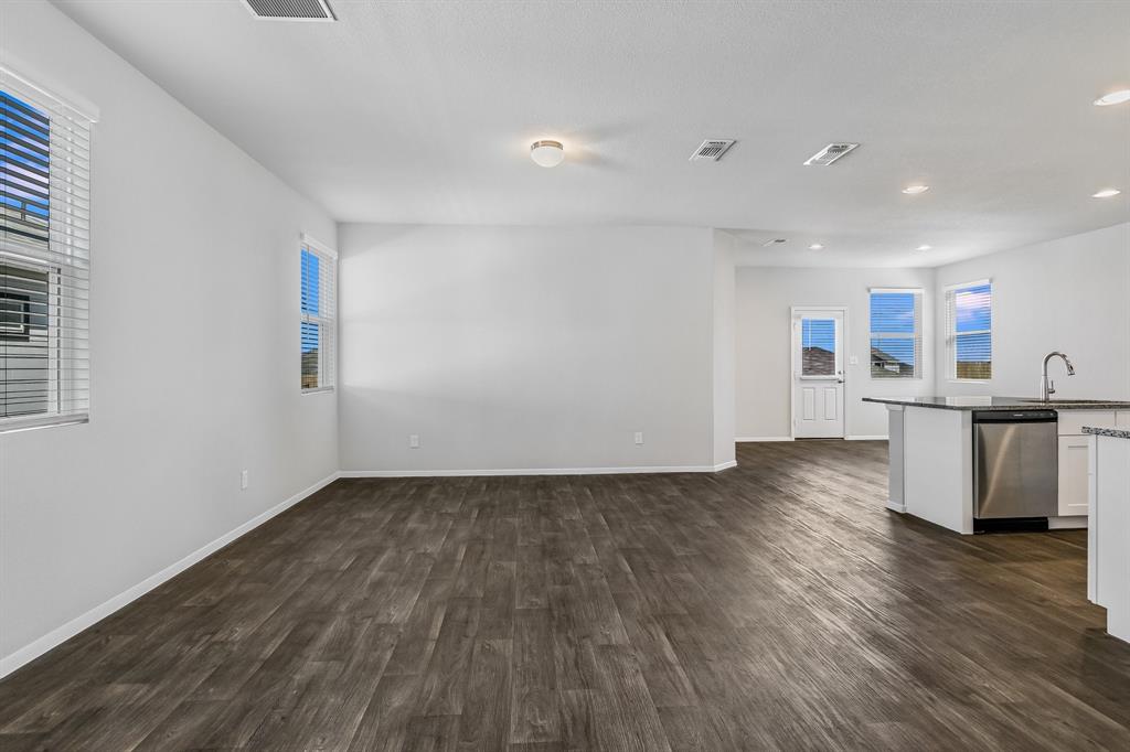 2808 Totley Road Manor, TX 78653 - Photo 5 of 21 Open-concept living space featuring wood-finish flooring, white walls, and multiple windows with blinds