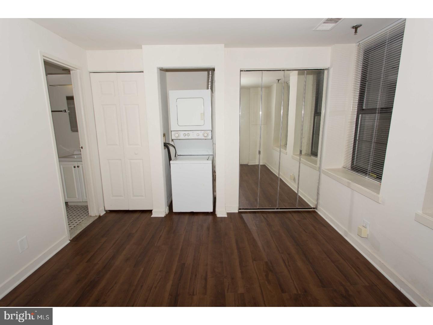 130 Arch Street, Unit 104 Philadelphia, PA 19106 - Photo 16 of 22 a view of an empty room with wooden floor and a window