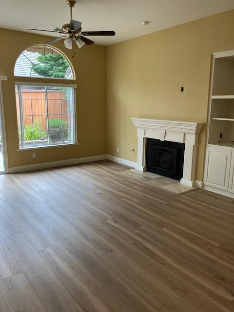 2157 West Rue St Michel Fresno, CA 93711 - Photo 5 of 22 an empty room with wooden floor a fireplace and windows