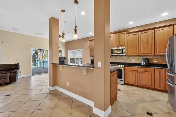 a kitchen with stainless steel appliances granite countertop a refrigerator a stove and a sink