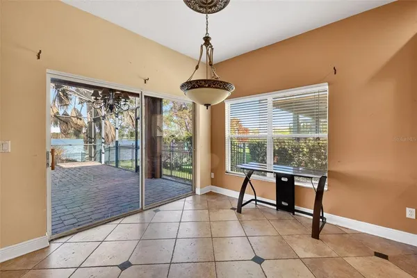 a dining room with furniture and a floor to ceiling window