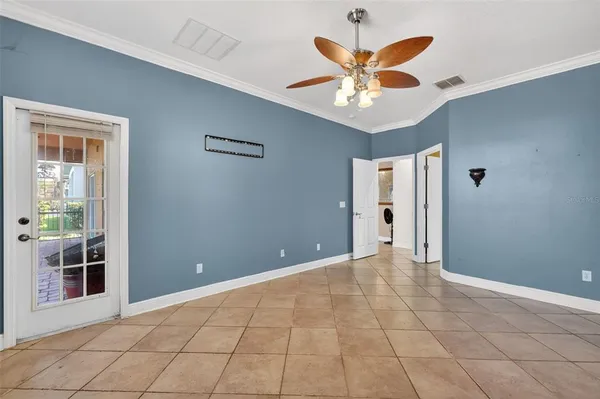 an empty room and chandelier fan