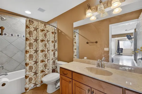 a bathroom with a granite countertop sink a toilet and a mirror