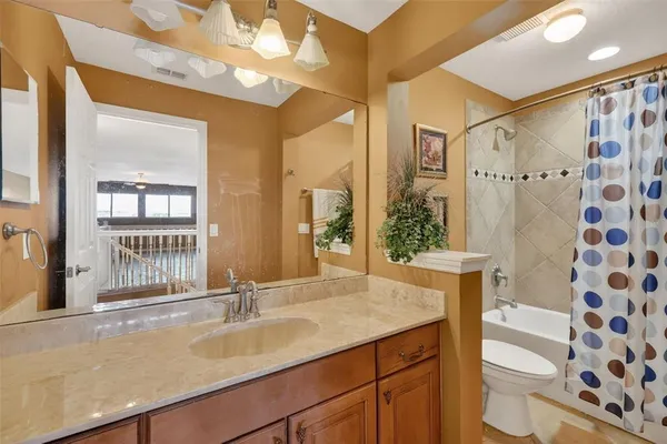 a bathroom with a granite countertop sink a mirror a vanity and shower