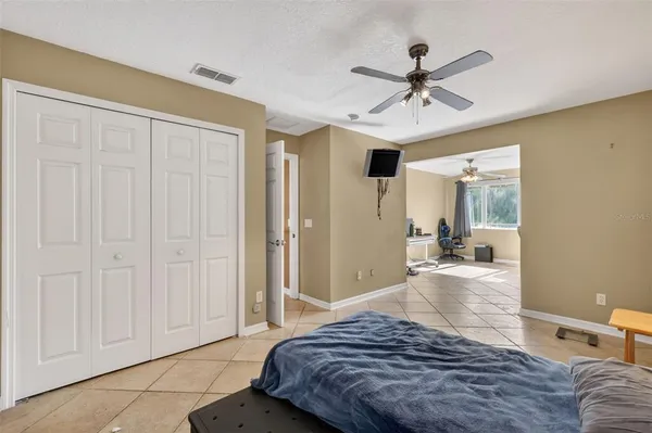 a bedroom with a large bed a chandelier and closet