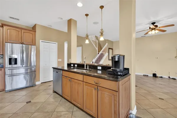a kitchen with stainless steel appliances granite countertop a sink a stove and a refrigerator