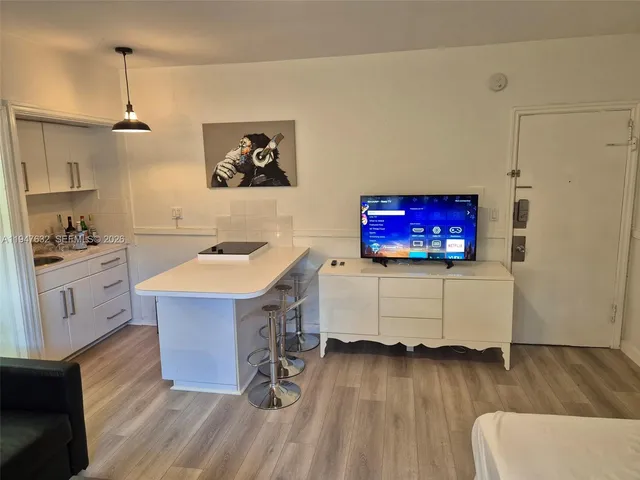 a room with a table chairs and a kitchen view