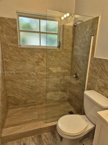 a bathroom with a toilet and a shower