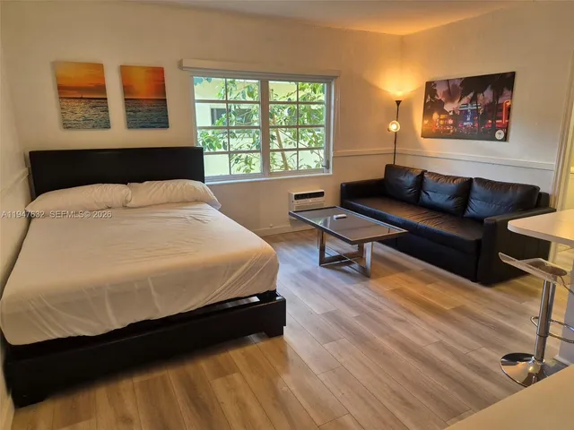 a spacious bedroom with a bed a couch and large window