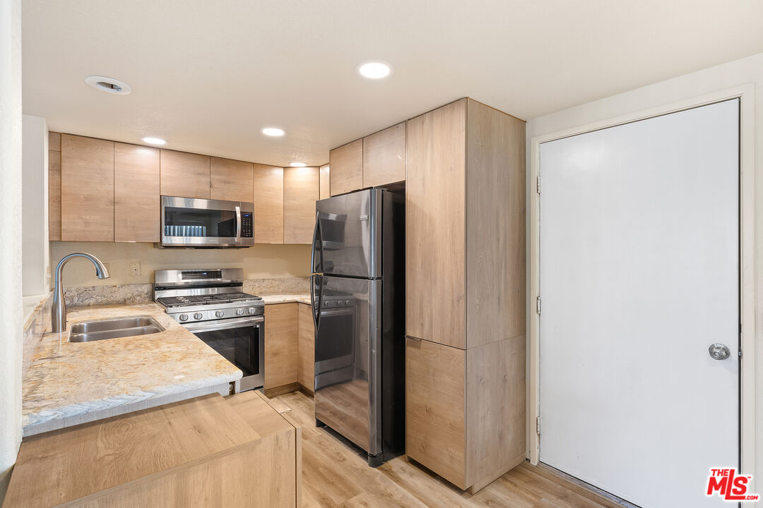 445 Ribbon Beach Way, Unit 277 Oceanside, CA 92058 - Photo 12 of 28 a kitchen with a refrigerator microwave and sink