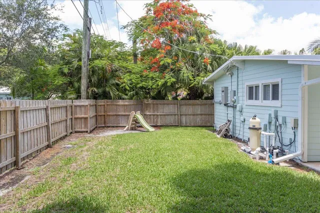 a view of backyard with small cabin and wooden fence