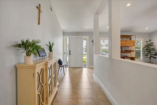 a hallway with wooden floor and a potted plant